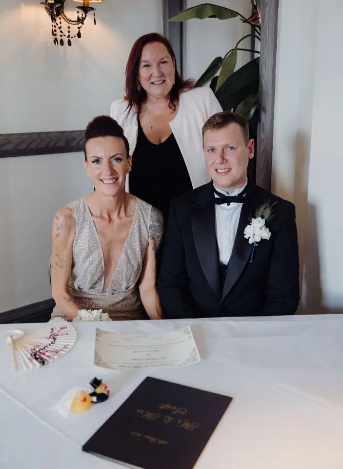 Eve and Michael signing their ceremony certificate